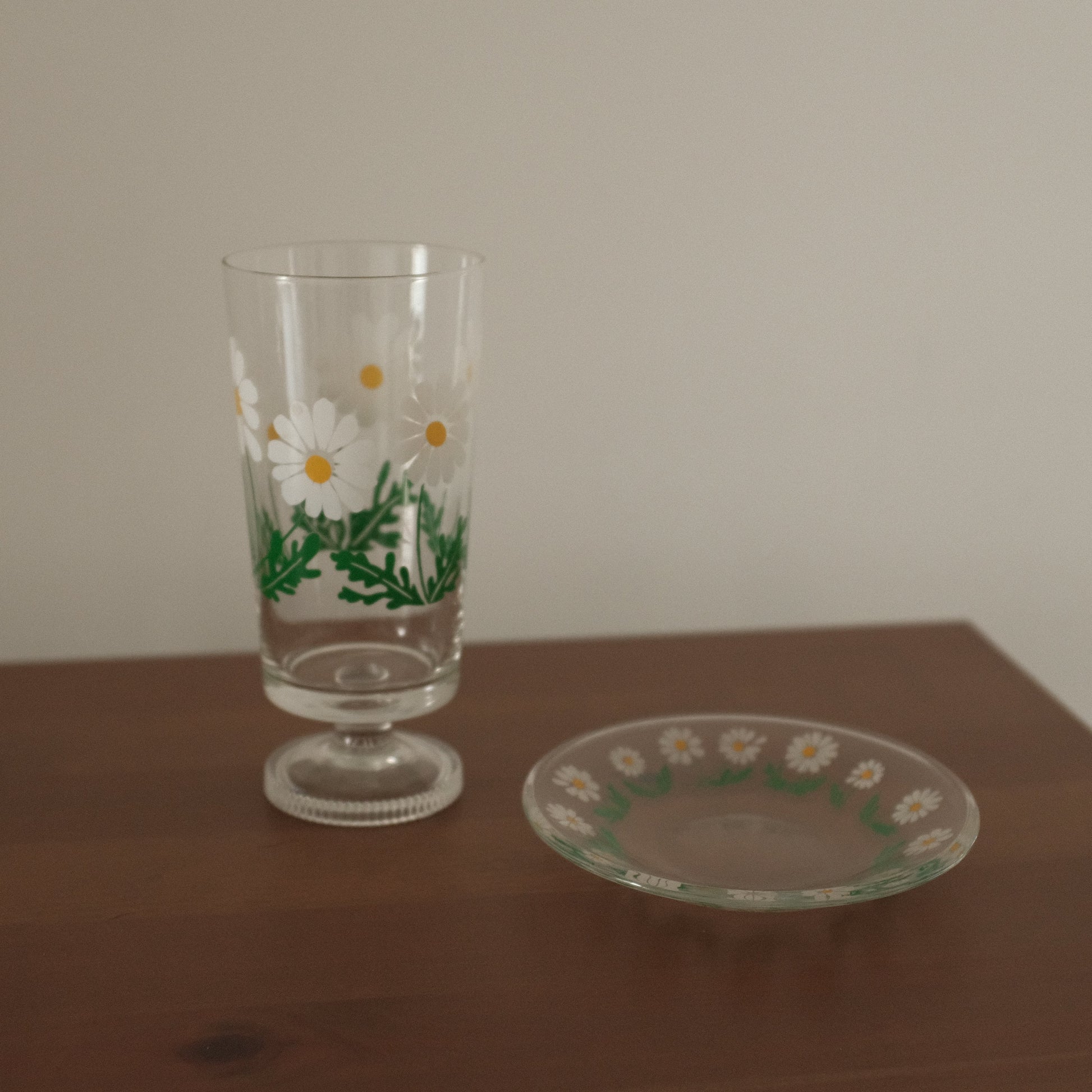Decorative glass with floral design on a wooden surface