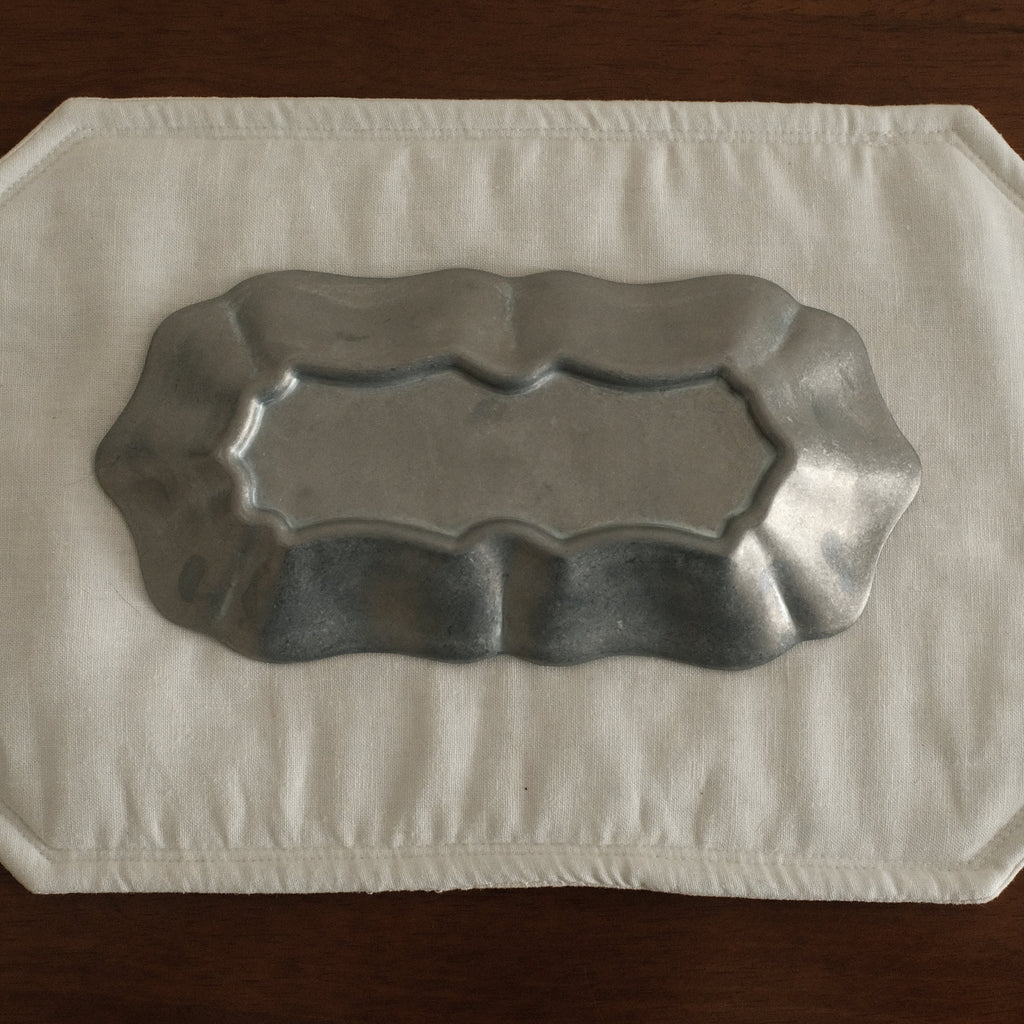 Grey metallic tray on a white paper towel on a wooden surface