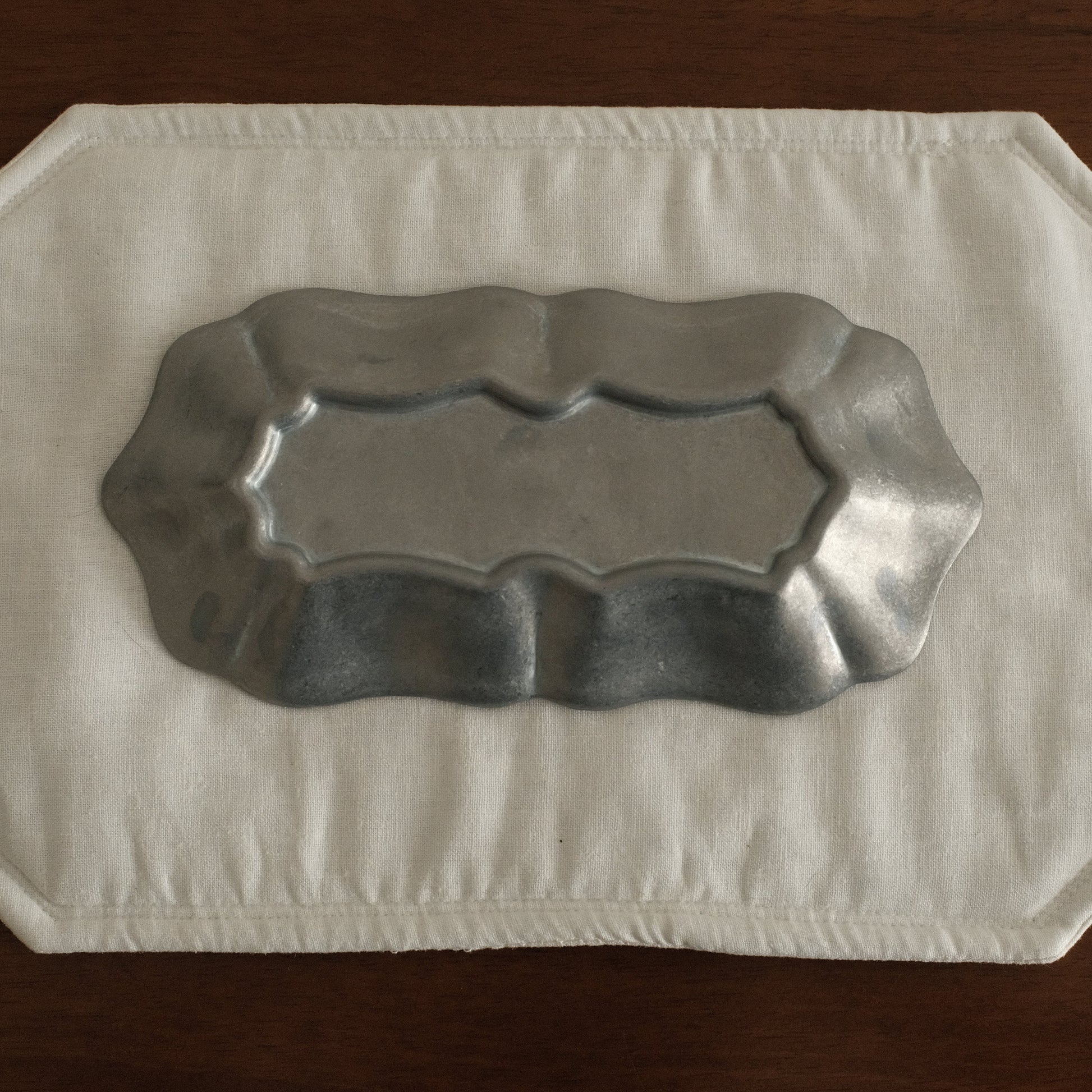 Grey metallic tray on a white paper towel on a wooden surface