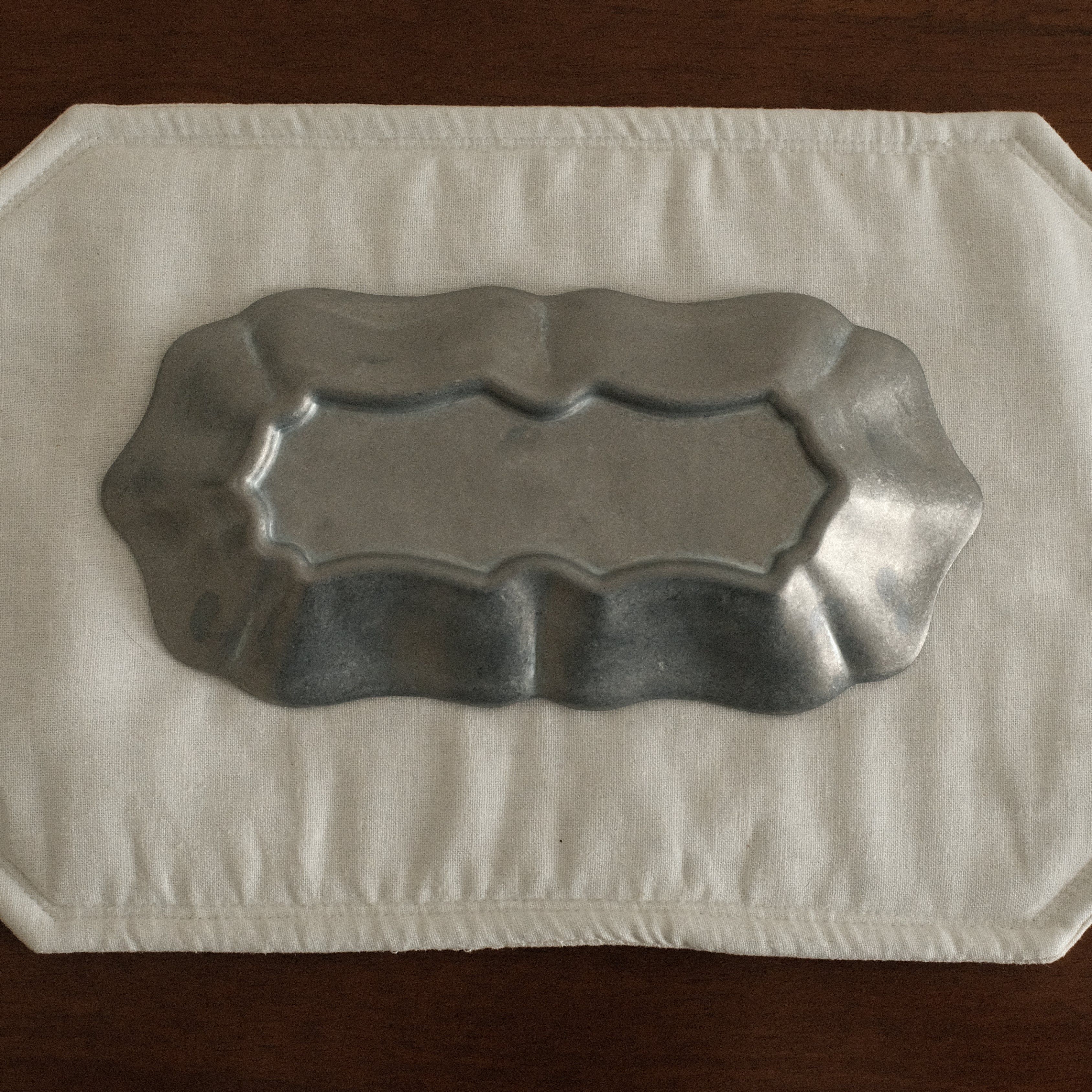 Grey metallic tray on a white paper towel on a wooden surface