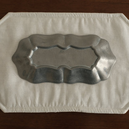 Grey metallic tray on a white paper towel on a wooden surface