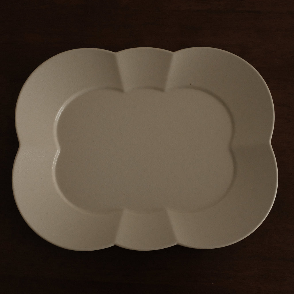 White ceramic platter on a dark brown surface