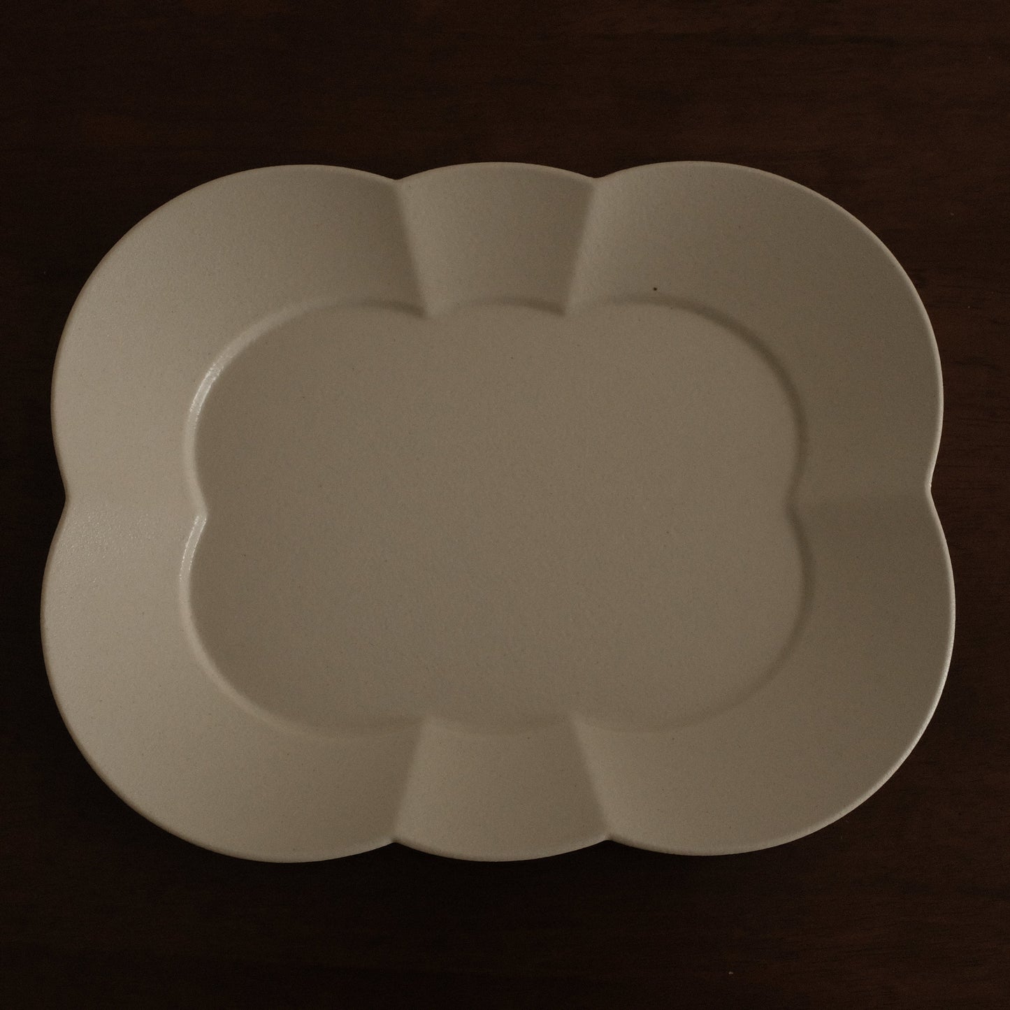 White ceramic platter on a dark brown surface
