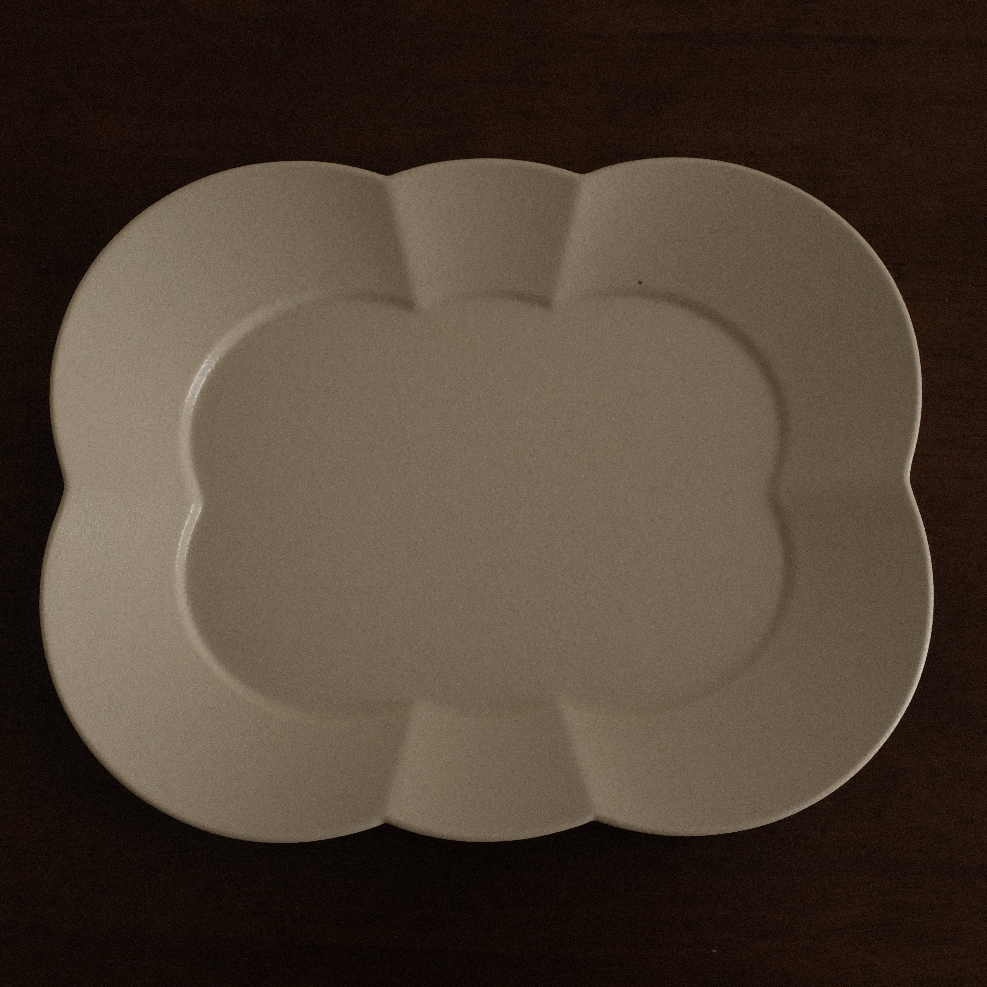 White ceramic platter on a dark brown surface