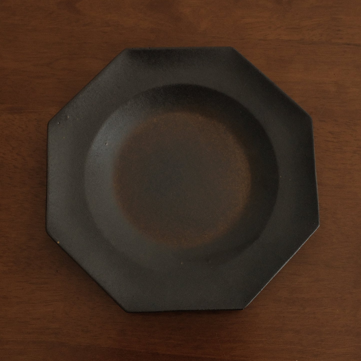 Black octagonal plate on a wooden surface