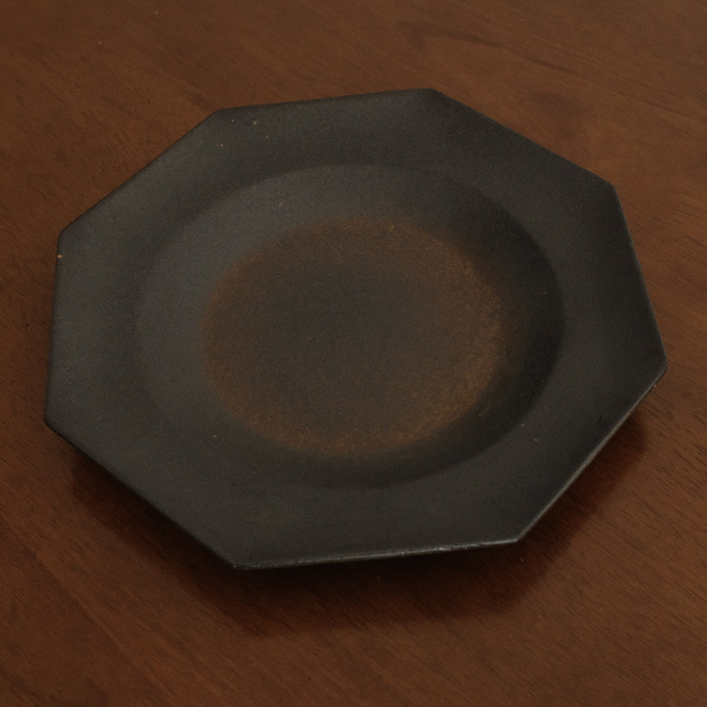 Black octagonal plate on a wooden surface