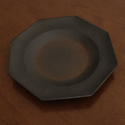 Black octagonal plate on a wooden surface