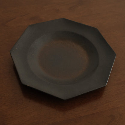 Black octagonal plate on a wooden surface