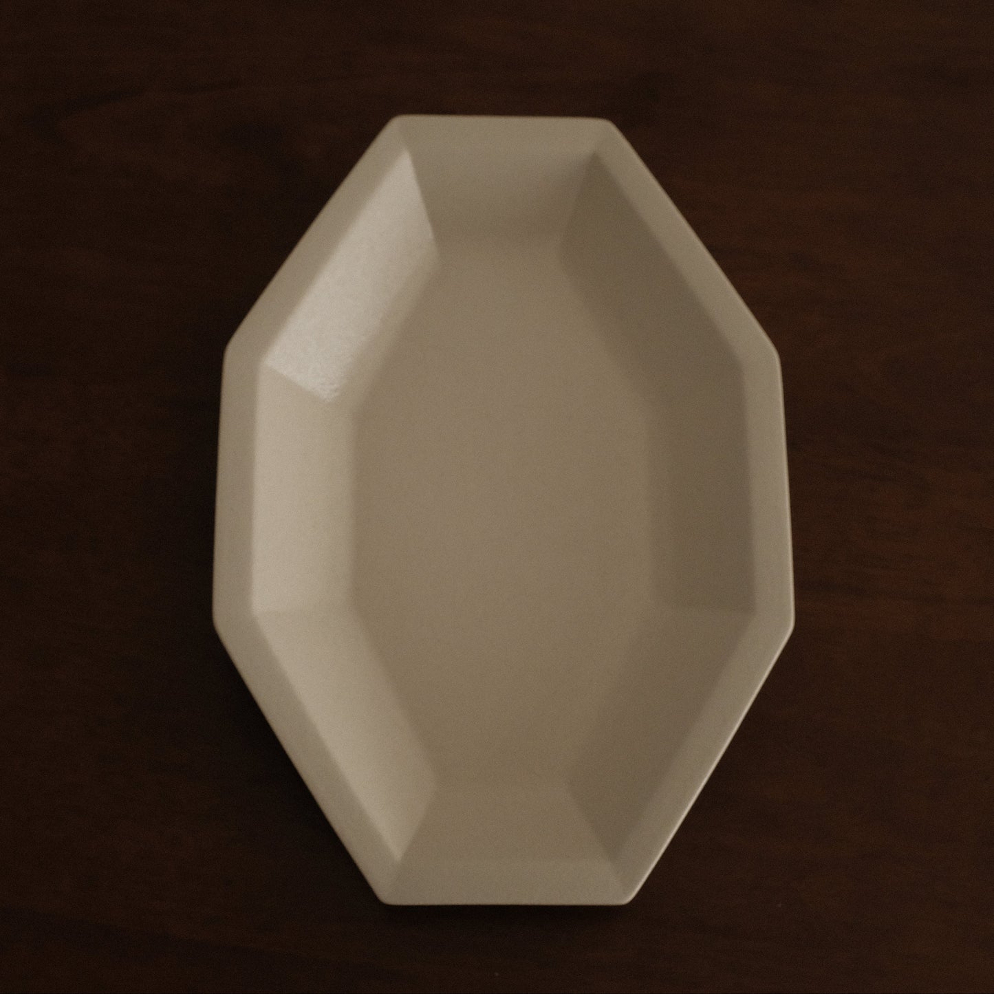 Beige octagonal dish on a dark brown background