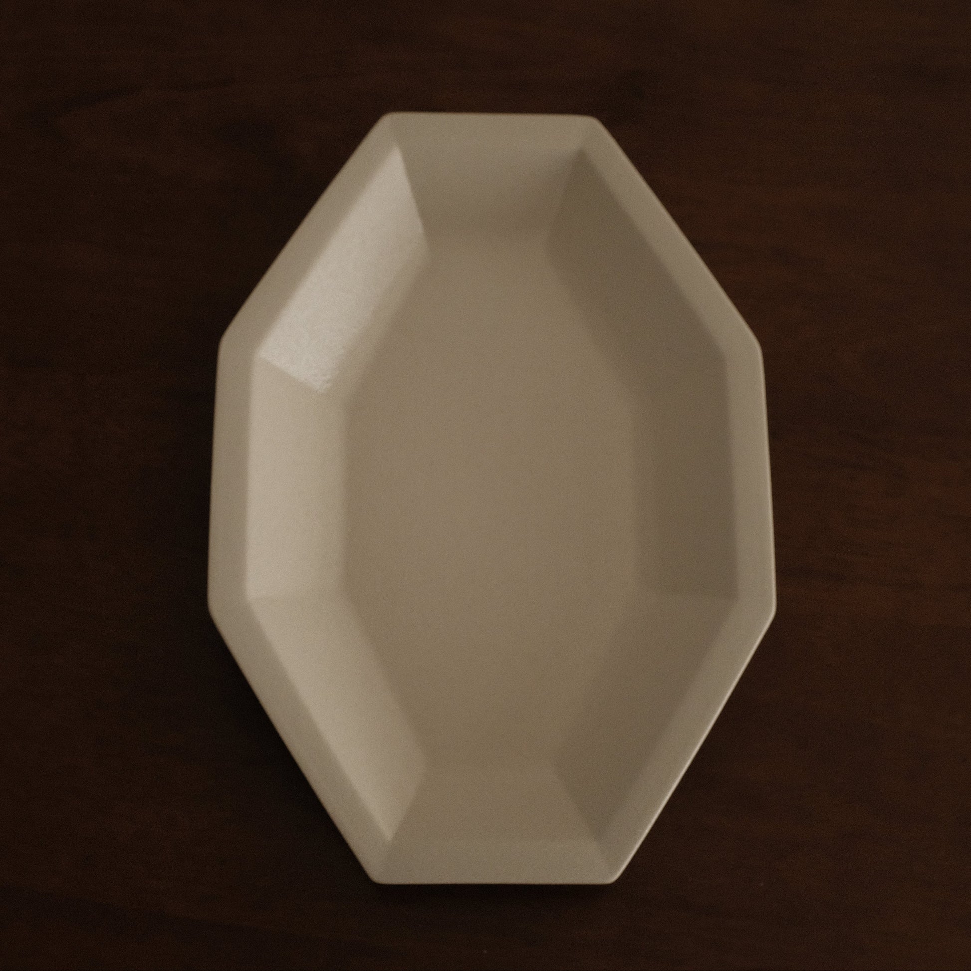 Beige octagonal dish on a dark brown background