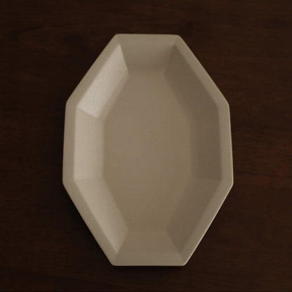 Beige octagonal dish on a dark brown background