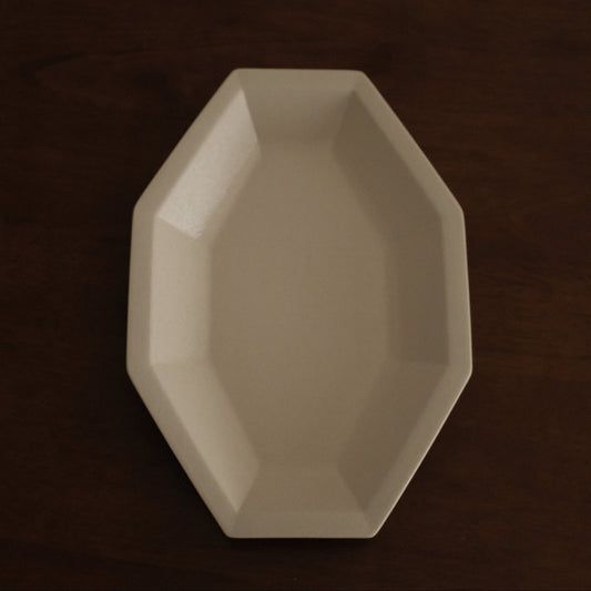 Beige octagonal dish on a dark brown background