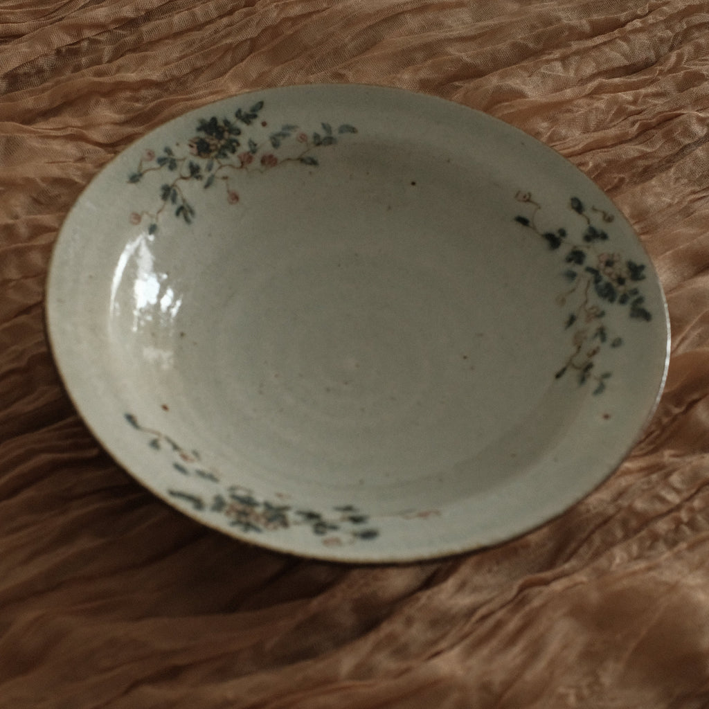 White ceramic bowl with floral patterns on a brown textured surface