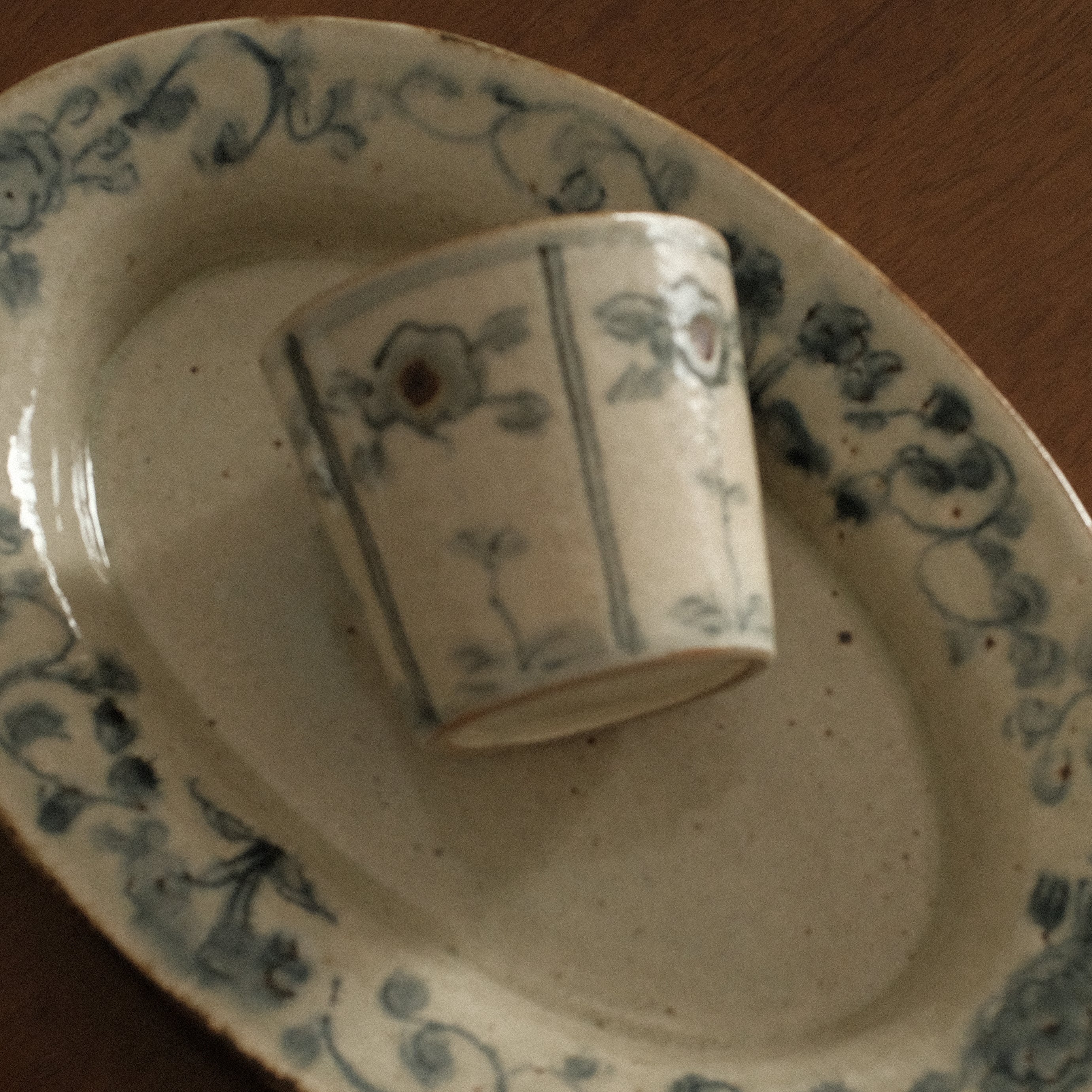Ceramic cup and saucer with floral patterns on a wooden surface