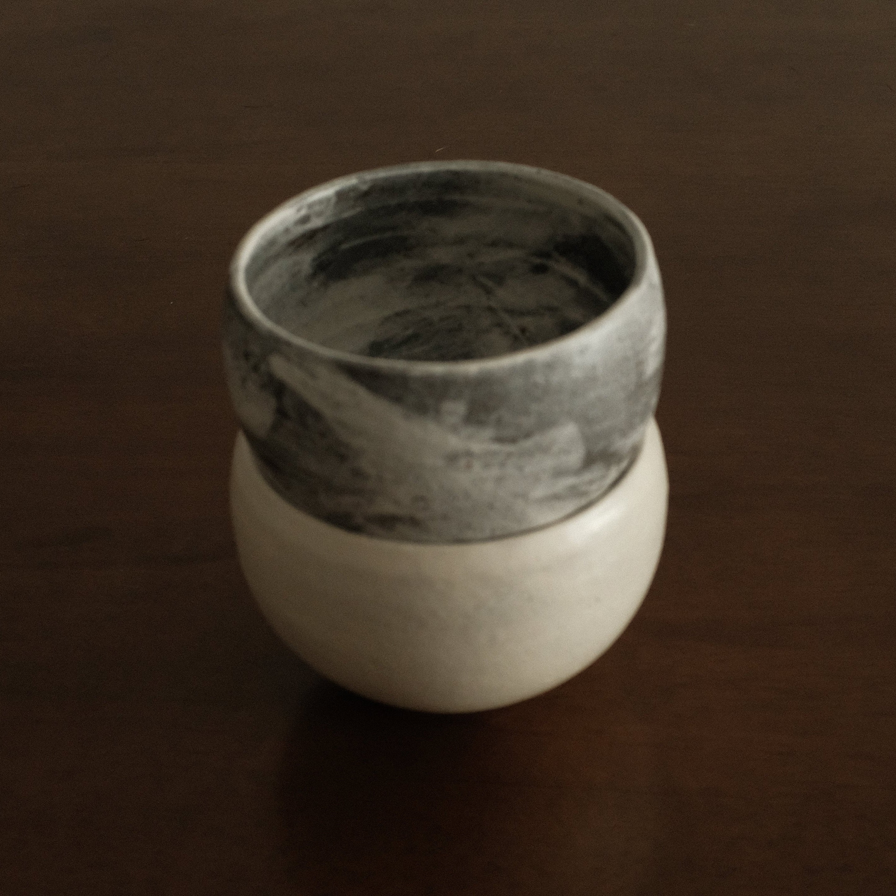 Ceramic cup with two-tone design on a dark surface
