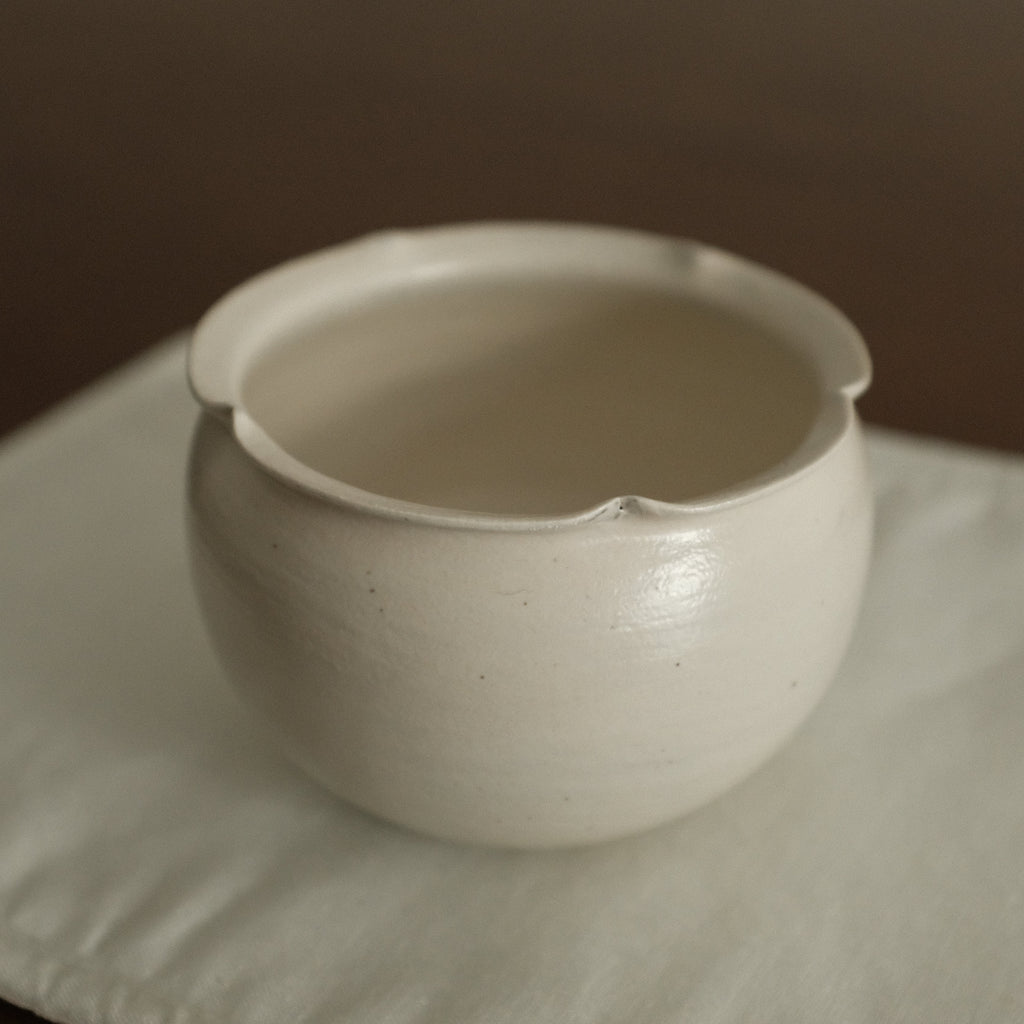 White ceramic cup on a textured surface with a neutral background