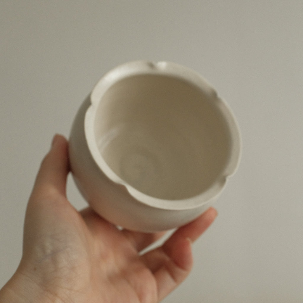 floral rim white ceramic cup against a plain background