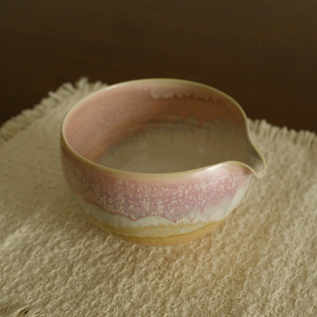 Ceramic bowl with a textured pink interior on a textured surface