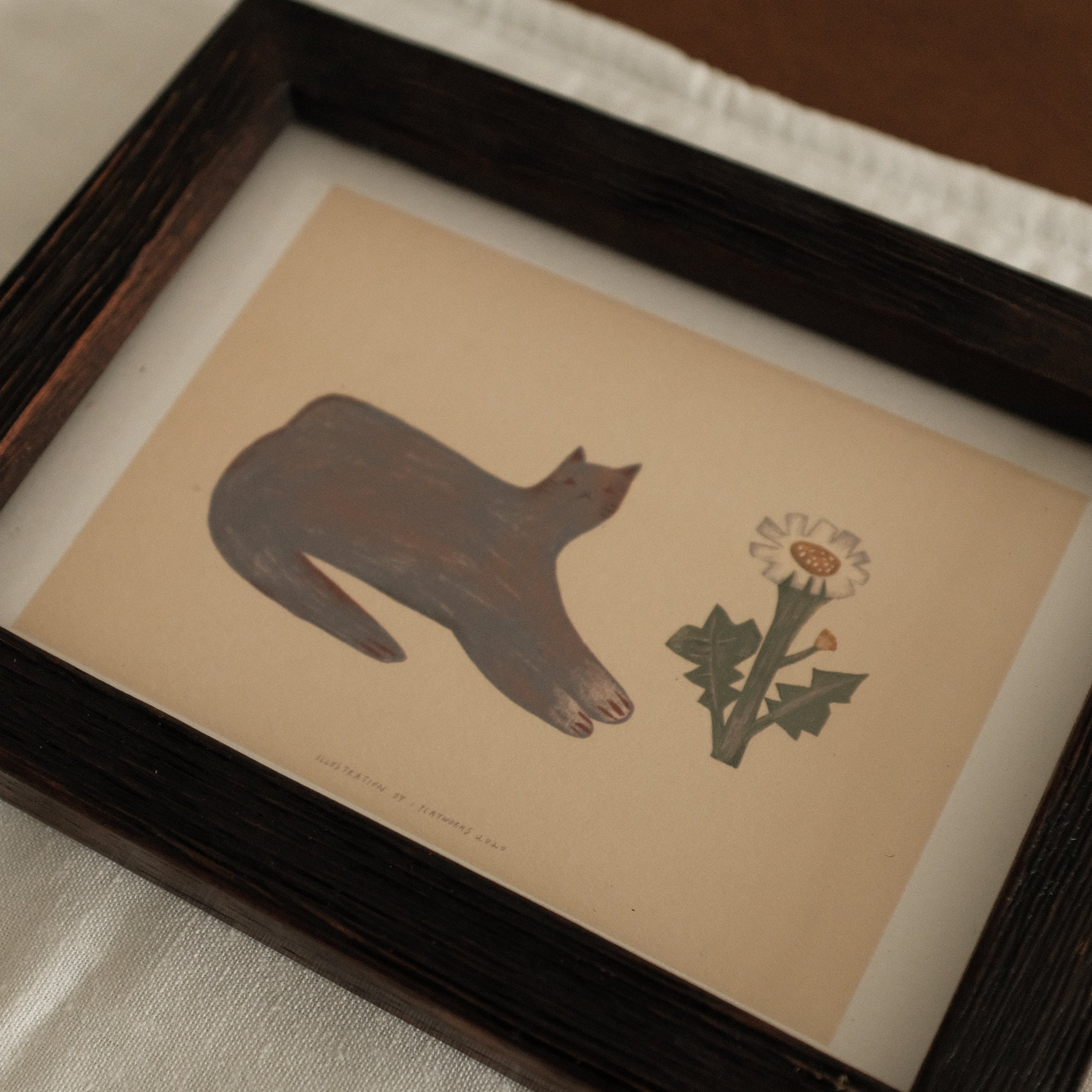 Teak Wood Framed artwork with a cat silhouette and flower on a white surface