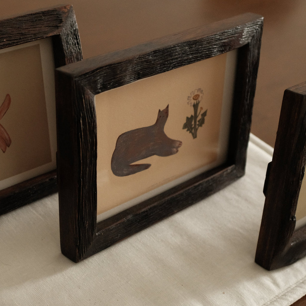 Three Teak Wood Framed artwork with a cat silhouette and flower on a white surface