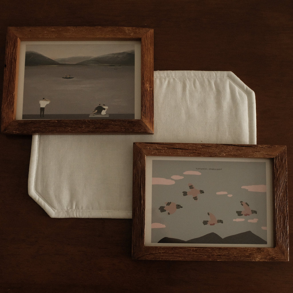 Two teak wood frame artworks on a dark brown background