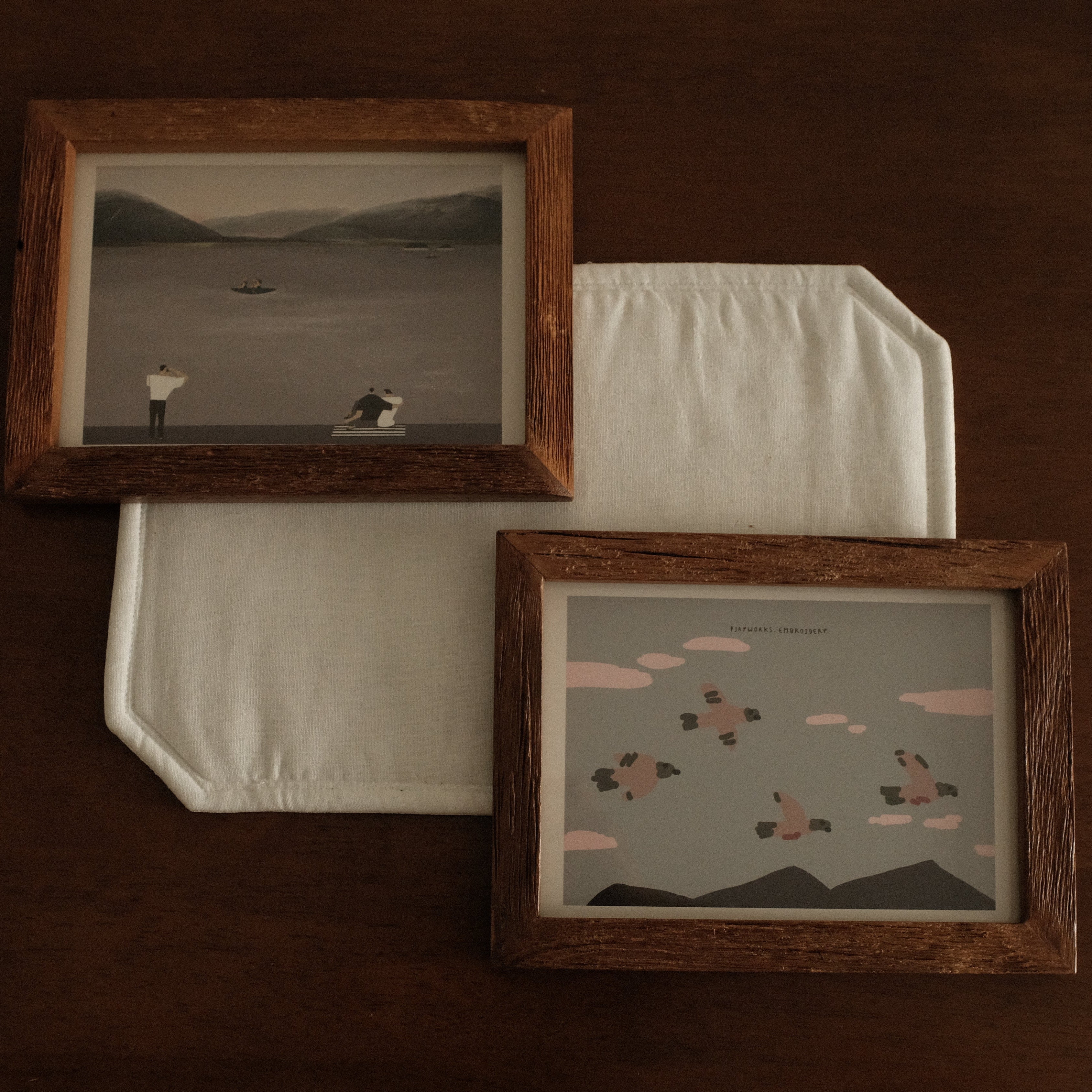 Two teak wood frame artworks on a dark brown background