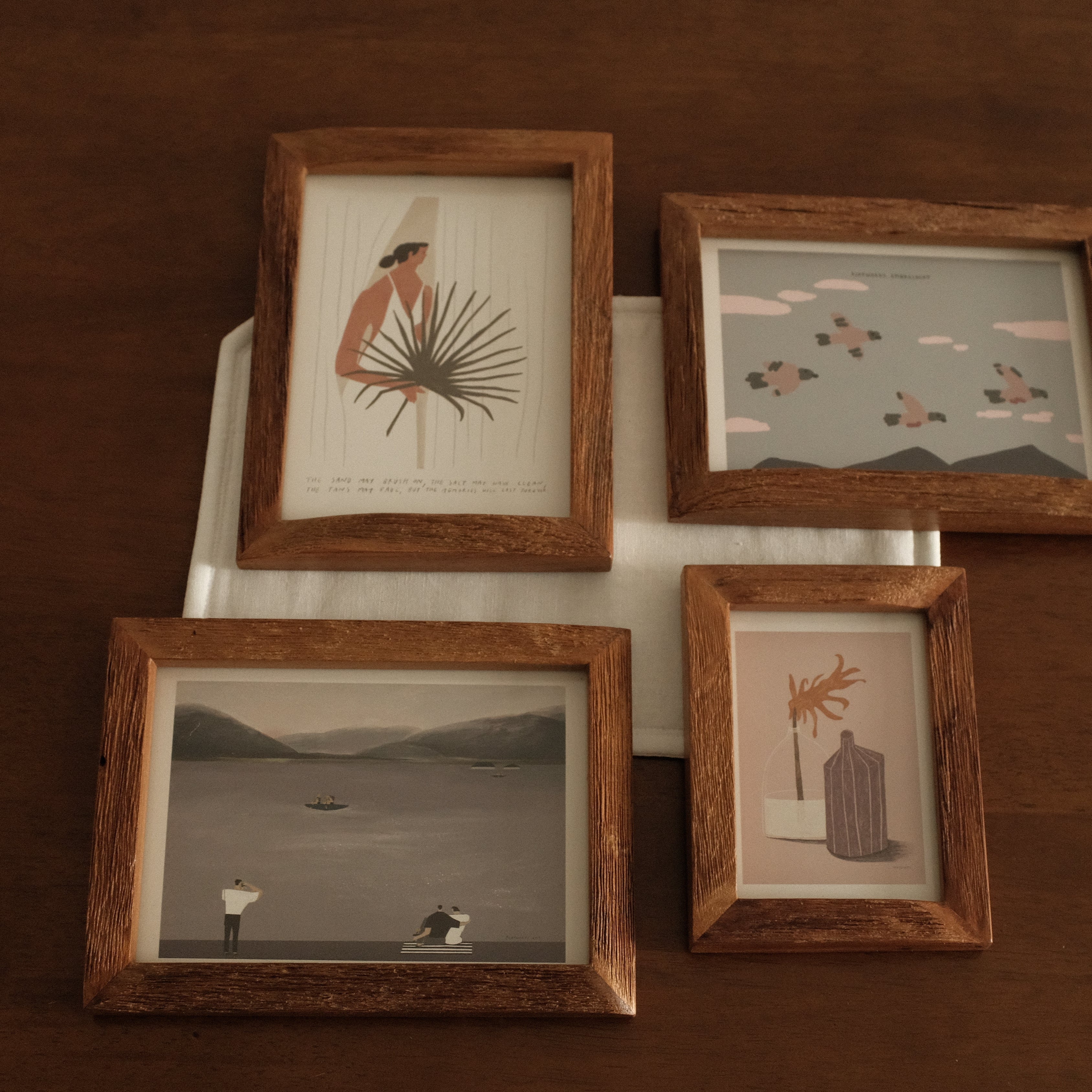 Teak wood framed artworks on a dark brown background