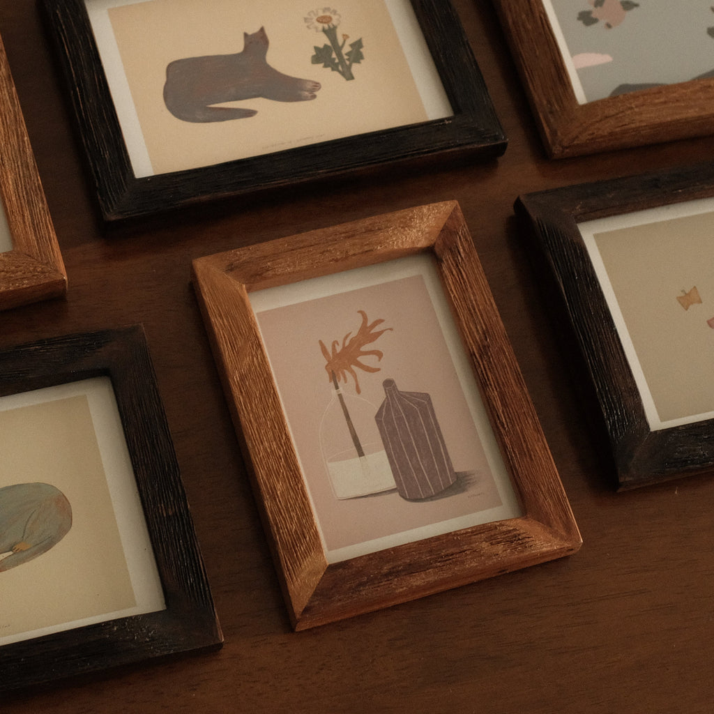 Collection of framed illustrations on a wooden surface