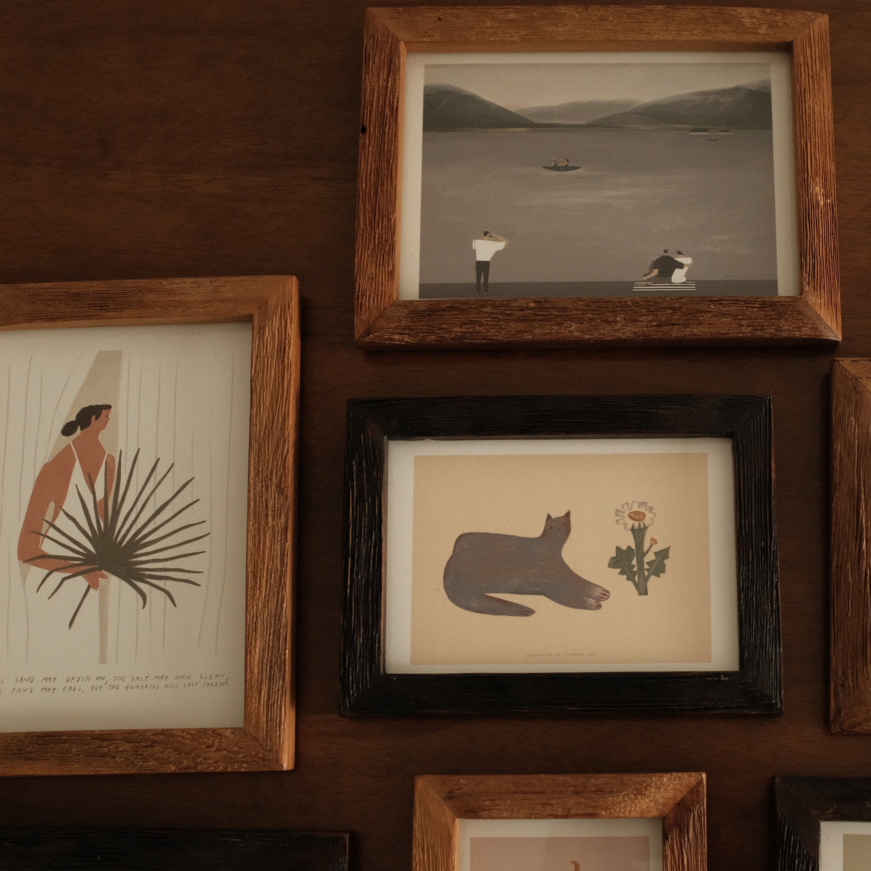 Collection of teak wood ramed artworks on a wooden wall