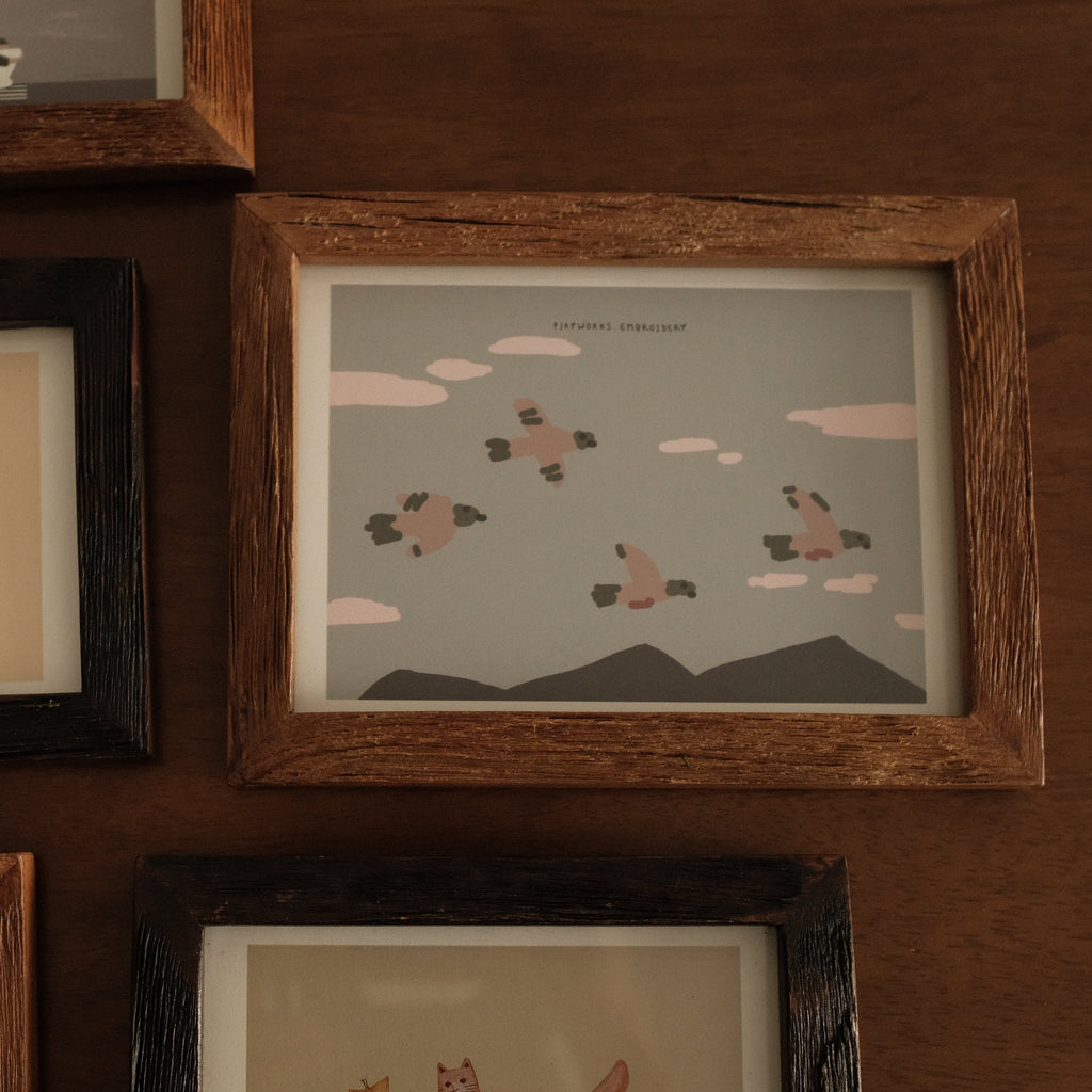 Collection of teak wood framed illustrations on a wooden wall
