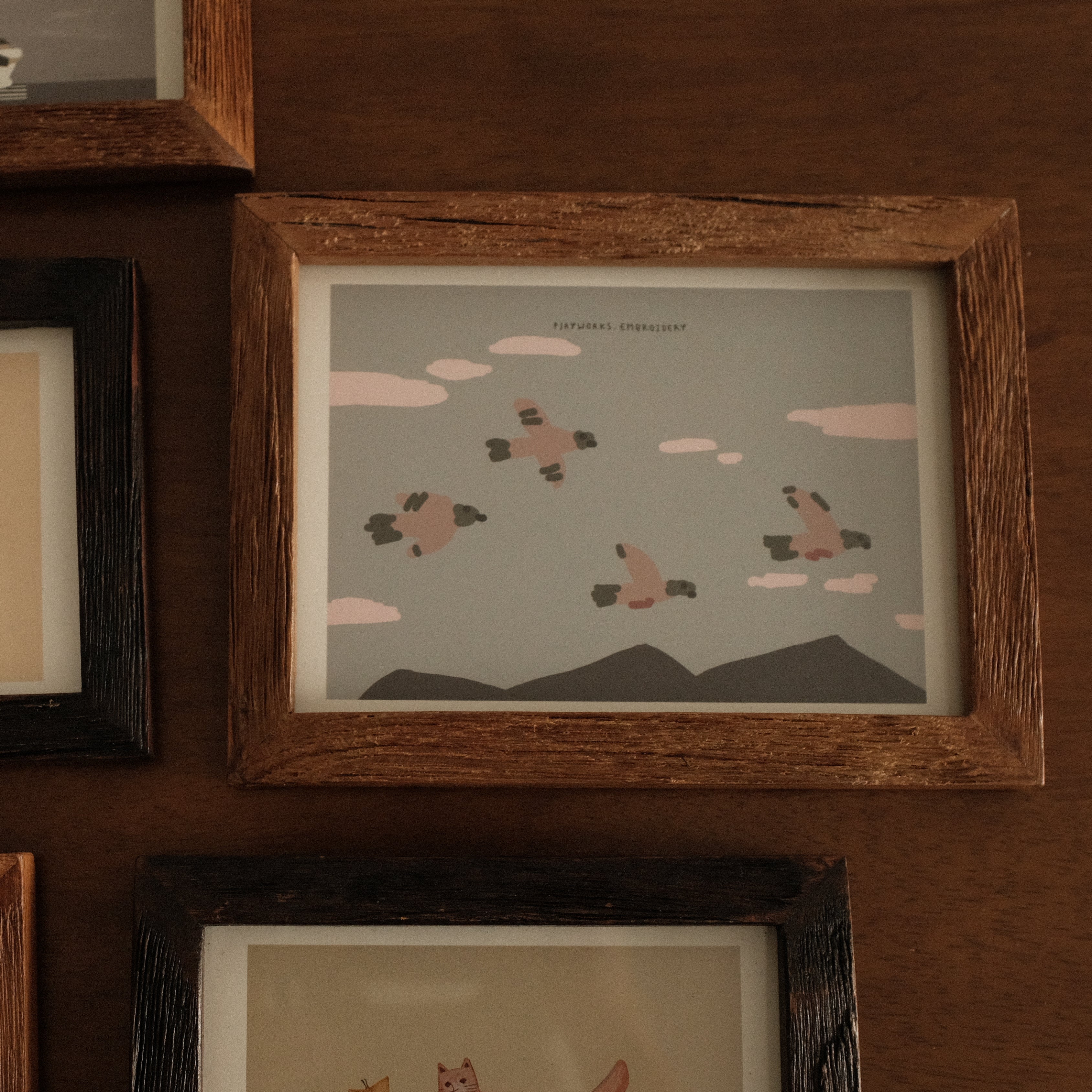 Collection of teak wood framed illustrations on a wooden wall
