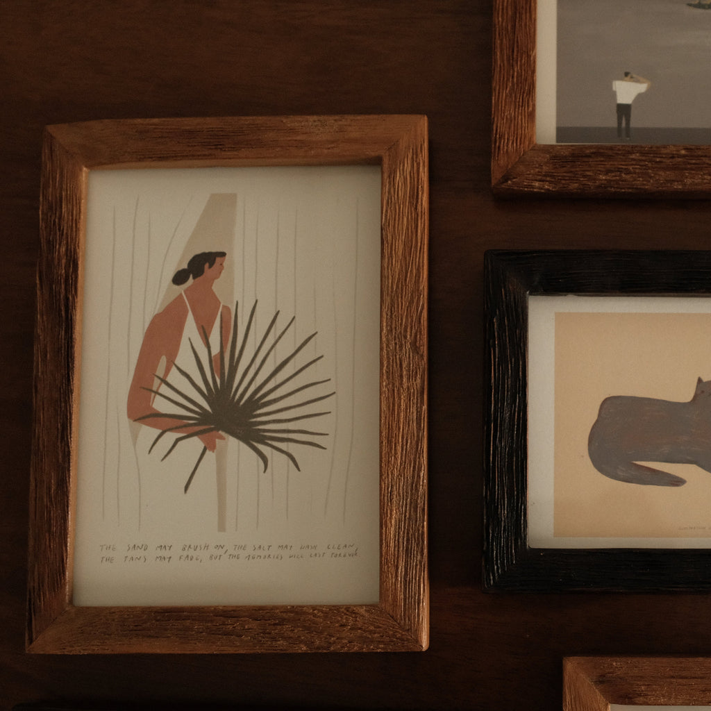 Collection of framed artworks on a wooden wall