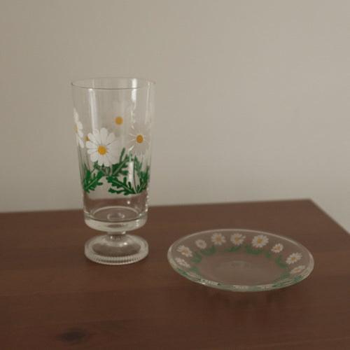 Decorative glass with floral design on a wooden surface
