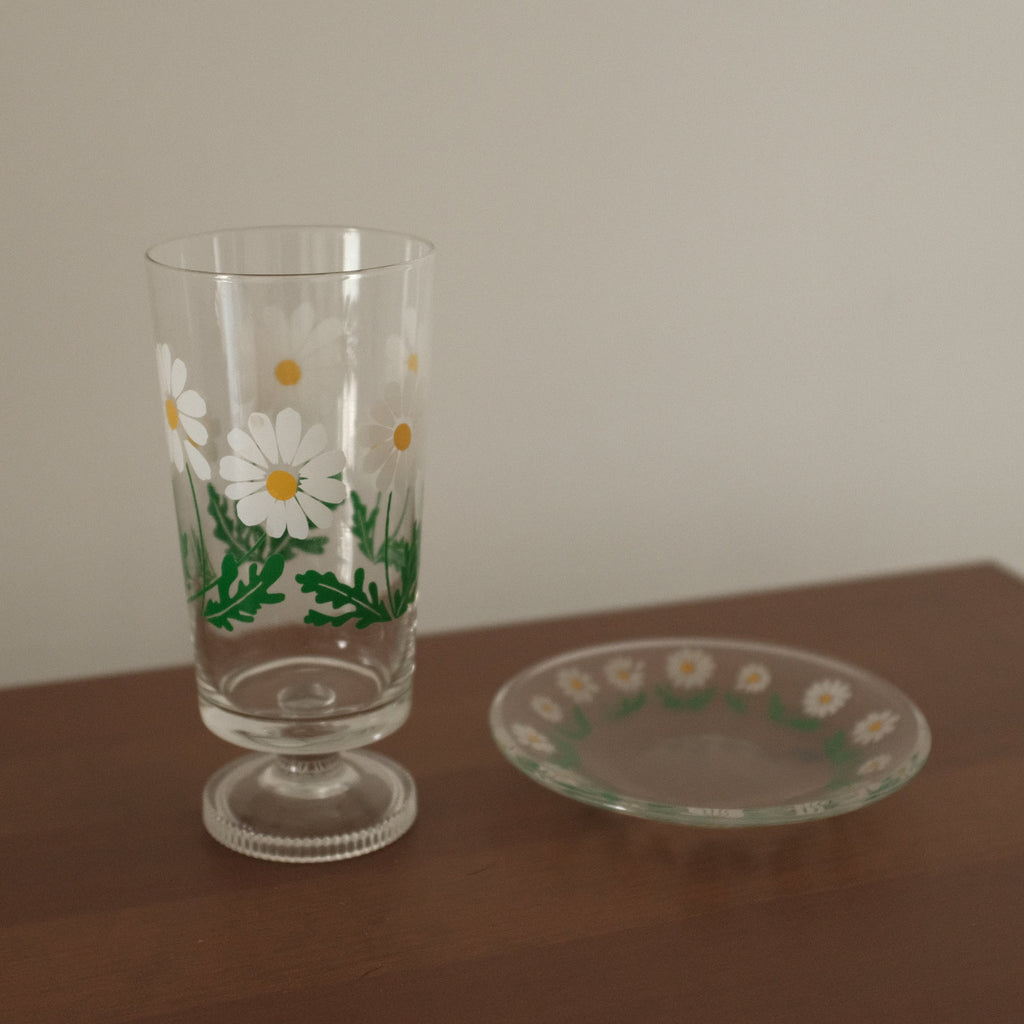 Decorative glass with floral design on a wooden surface