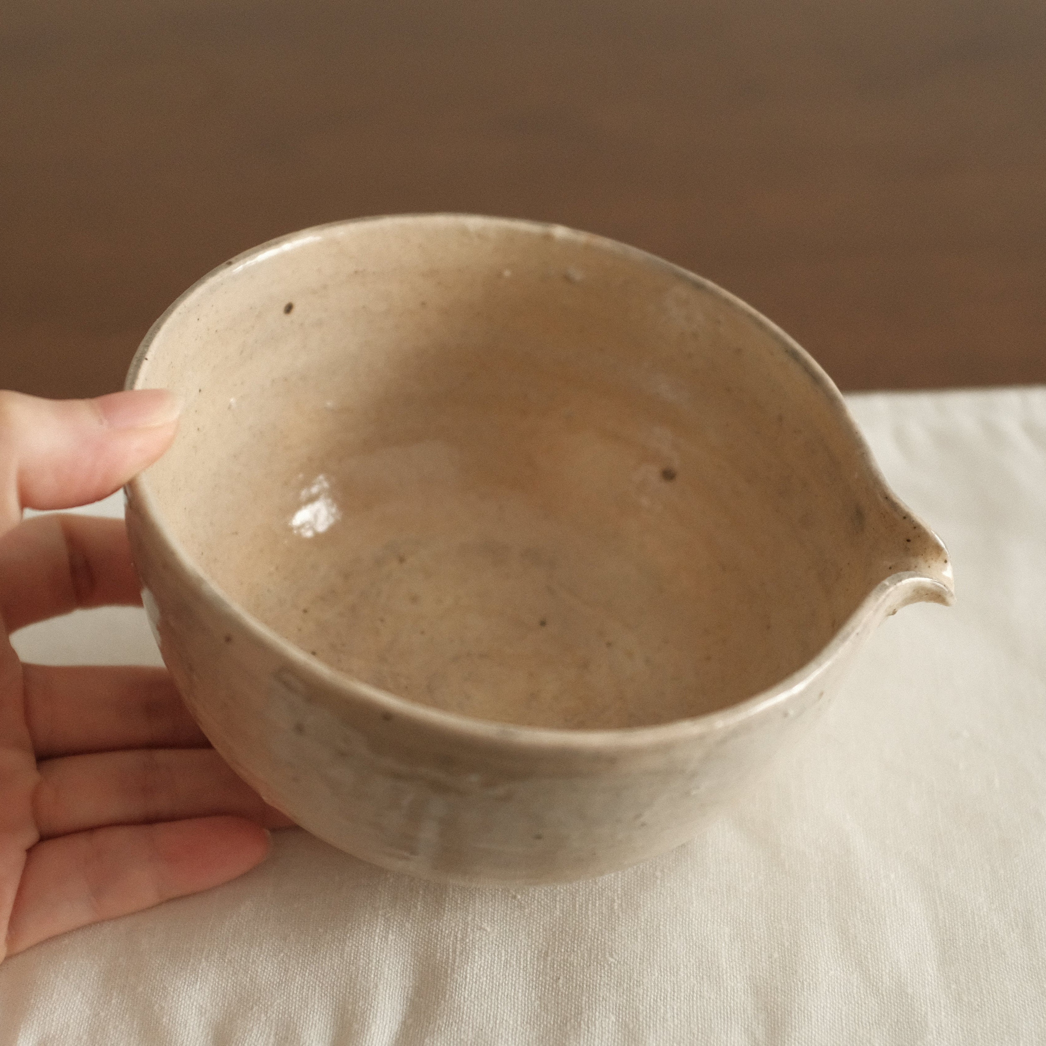 Ceramic bowl on a white cloth with a wooden background