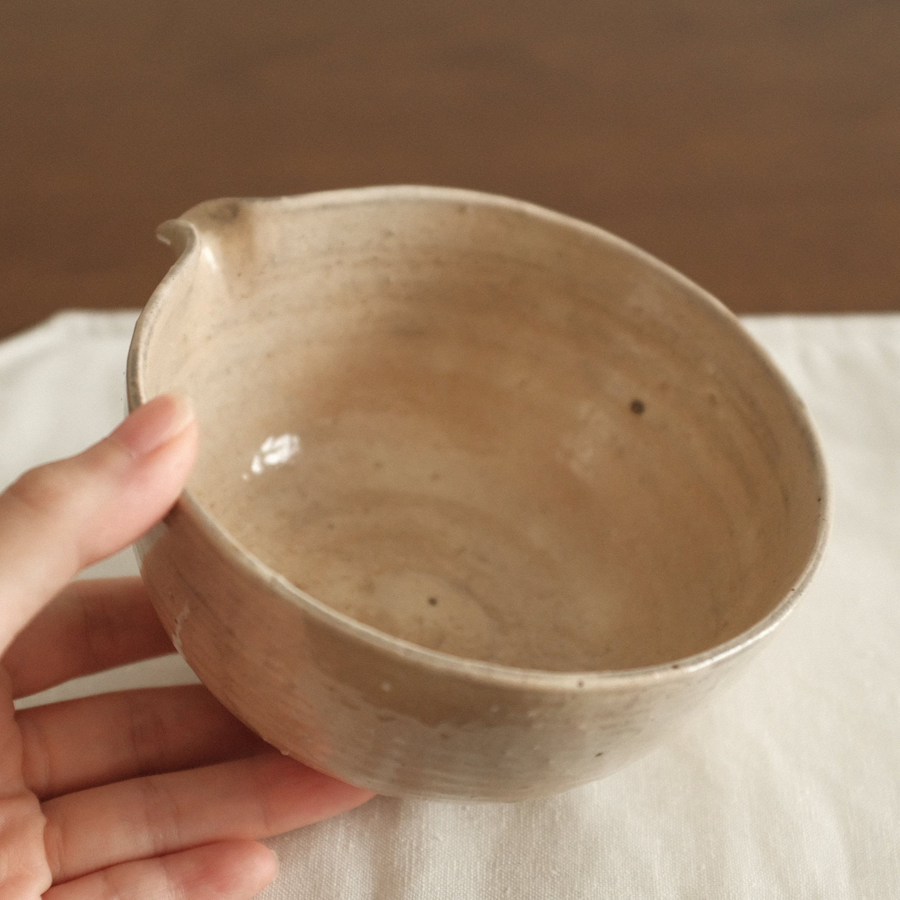 Ceramic bowl on a white cloth with a wooden background