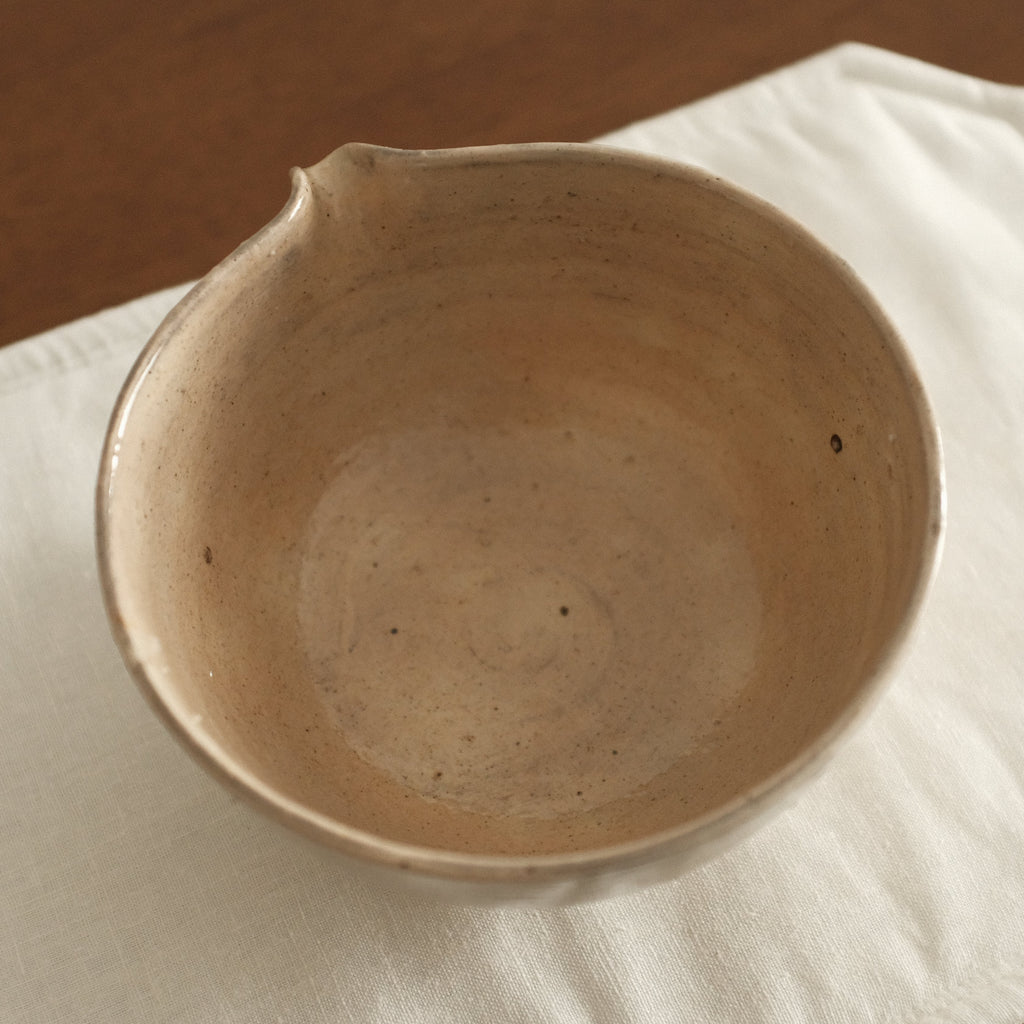 Ceramic bowl on a white cloth with a wooden background