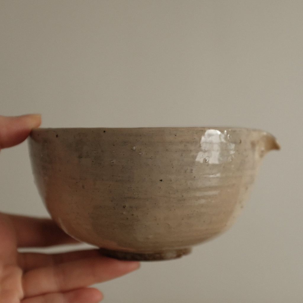 Ceramic bowl on a white cloth with a wooden background