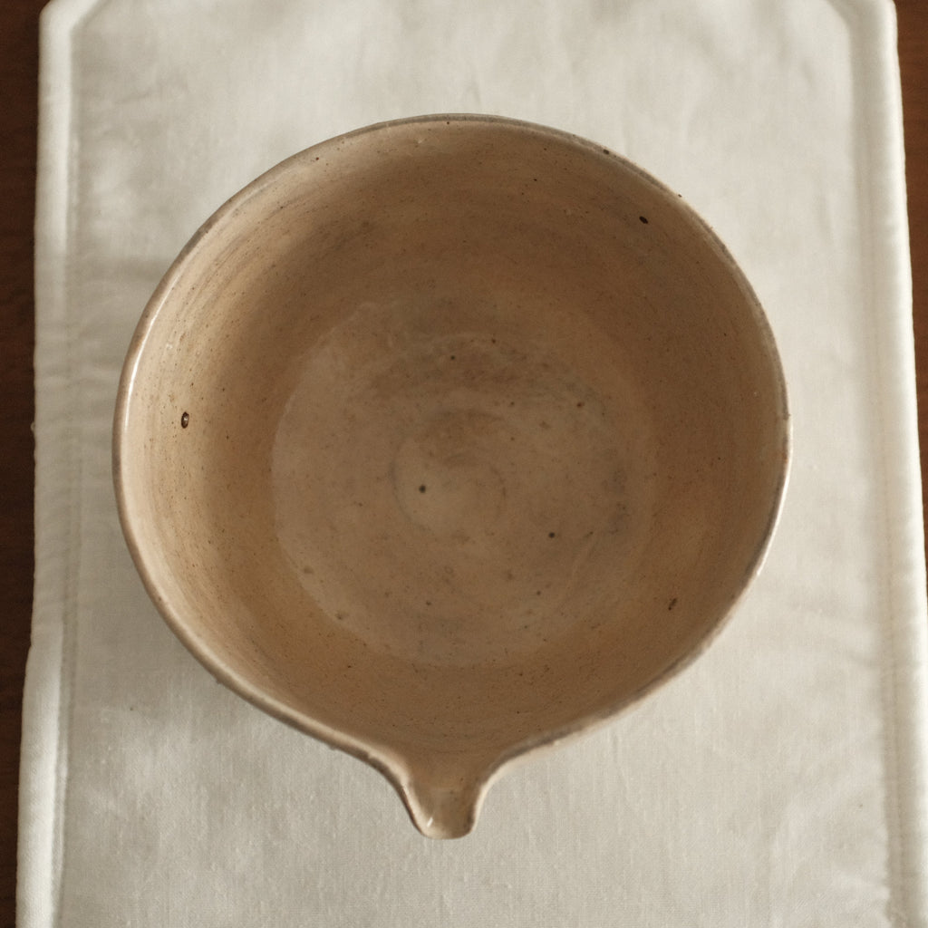 Ceramic bowl on a white cloth with a wooden background