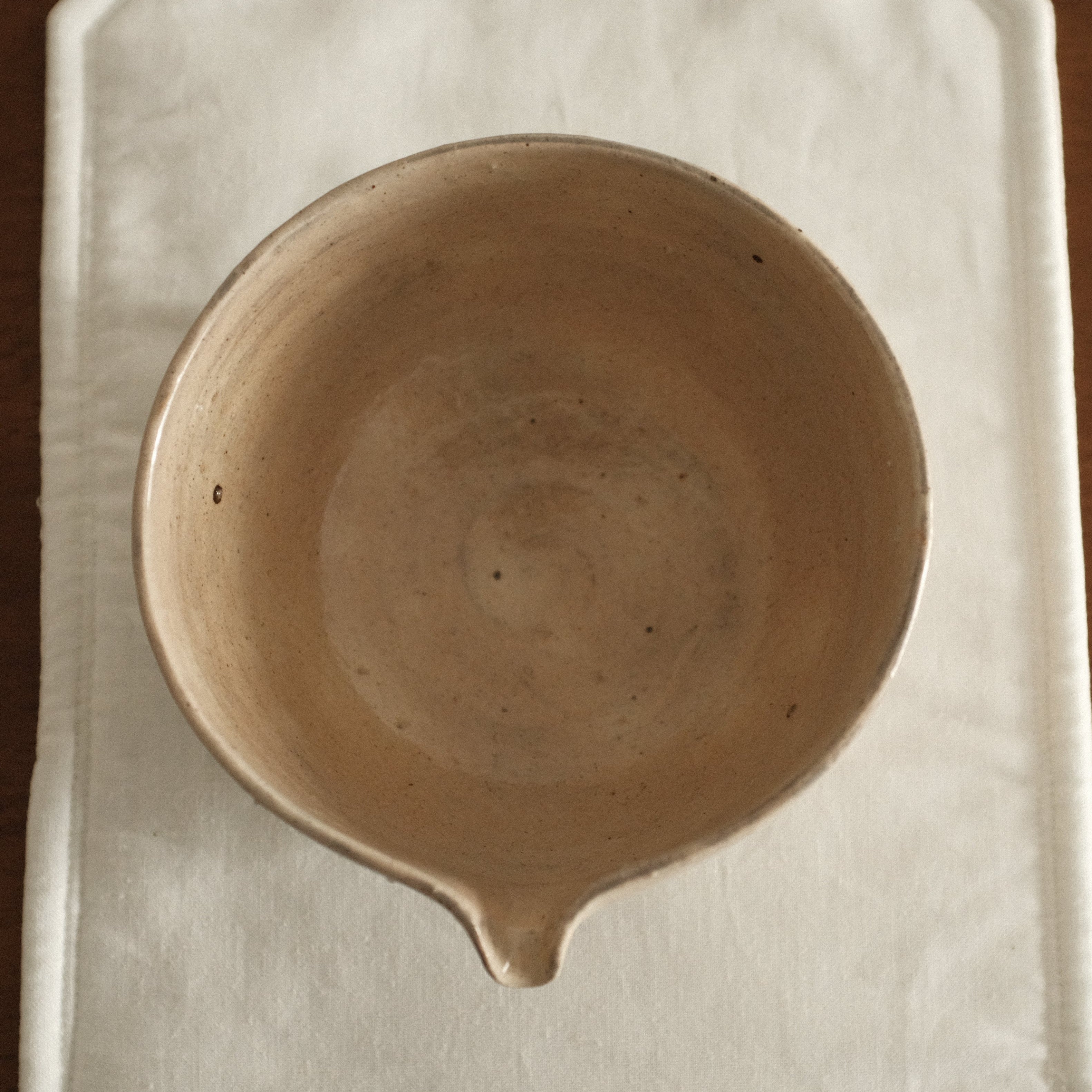 Ceramic bowl on a white cloth with a wooden background
