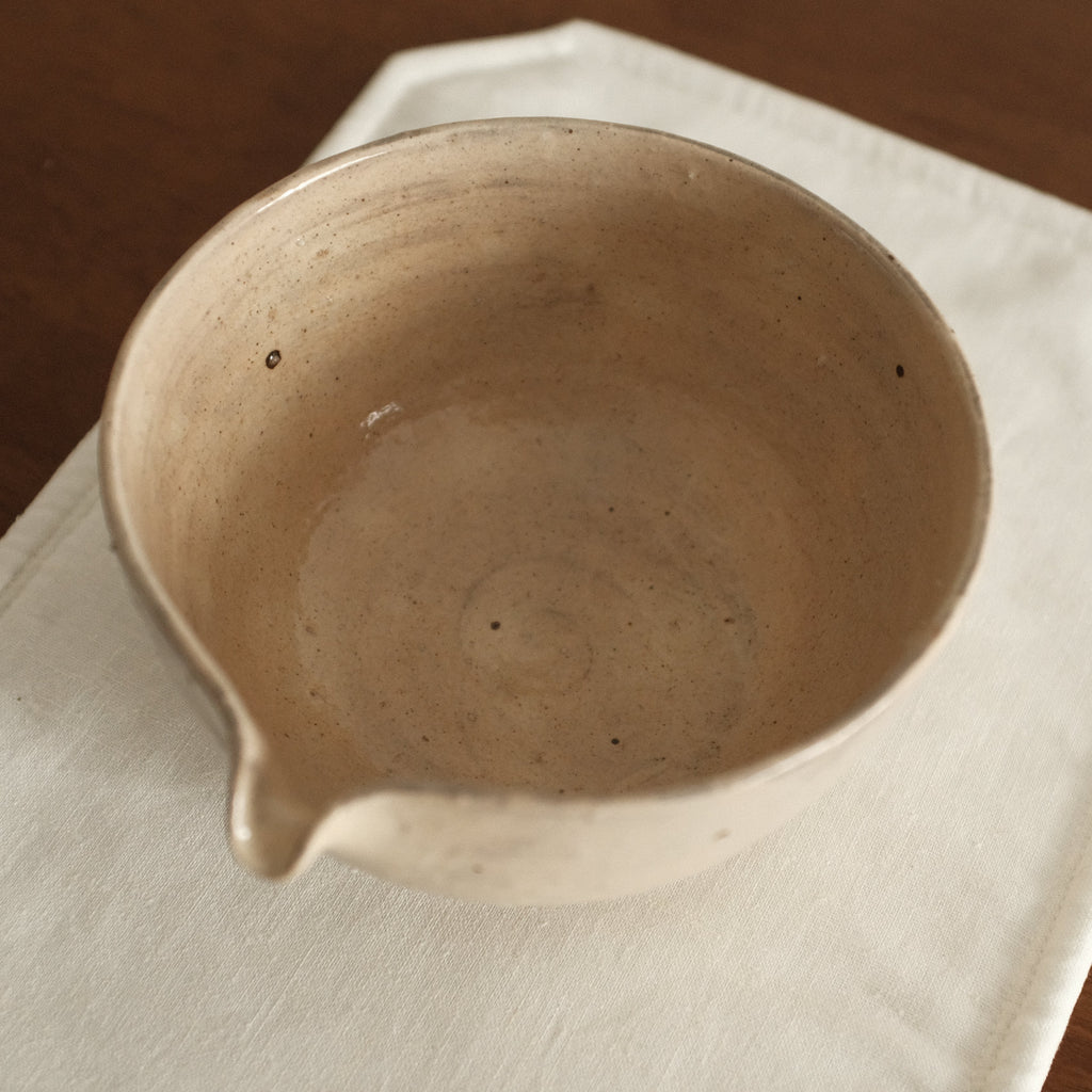 Ceramic bowl on a white cloth with a wooden background