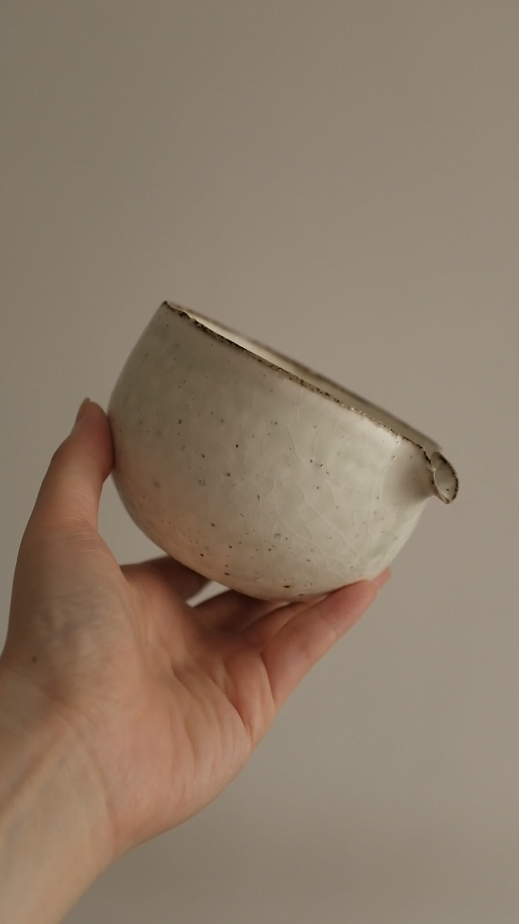 Handcrafted by artisan Yu Ming Li, this katakuchi matcha bowl embodies the harmony of tradition and subtle artistry. Its distinctive spouted form—designed for whisking and gracefully pouring matcha—also makes it a versatile piece for serving sauces, dressings, or shared tea moments.

Finished in a soft matte white powdered glaze, the surface carries gentle green undertones that emerge like mist over porcelain hills, shifting beautifully with light and shadow. The glaze’s natural variations ensure that each 